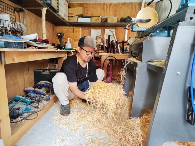 木屑を集める男性