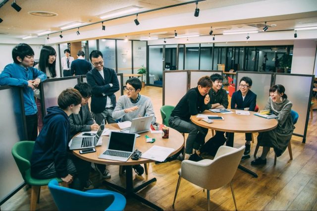 オフィスで活発に議論する若者たち