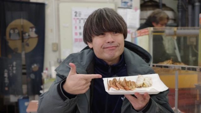 カニの足を指す男性