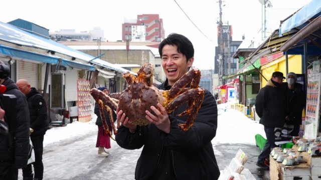 巨大なカニを抱える男性