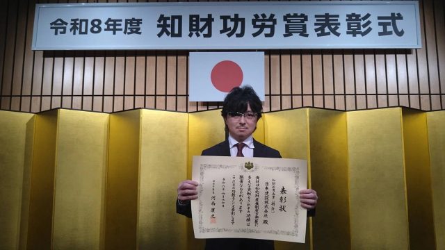 表彰状を掲げる社長