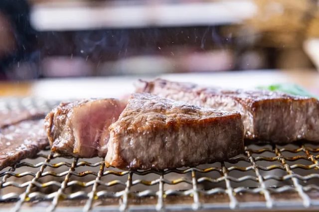 炭火で焼かれる厚切りの白老牛